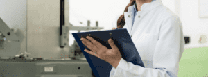 Person in laboratory wearing labcoat holding a clipboard