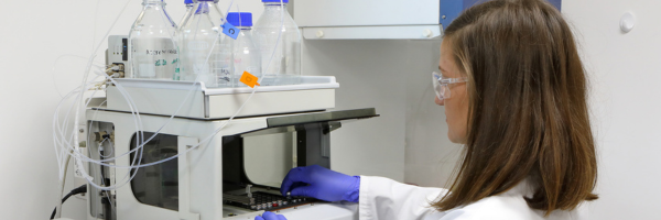 Researcher using HPLC equipment for chemical analysis and compound detection.