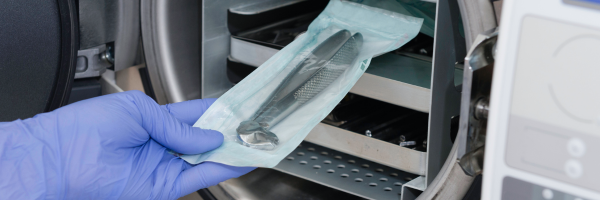 Medical instrument sealed in a paper-film sterilisation pouch during autoclave loading