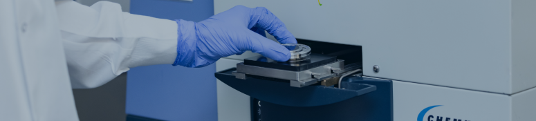 Laboratory technician loading a sample into an automated rapid microbiological testing system in a controlled laboratory environment.